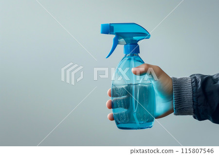 A person is holding a blue spray bottle A person is holding a blue spray bottle 115807546