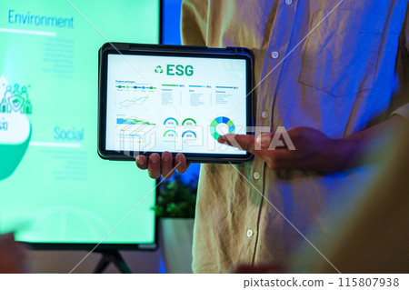 diversity team presentation about ESG (environment,socail,governance)  sustainability business goals sdgs in green office at night 115807938