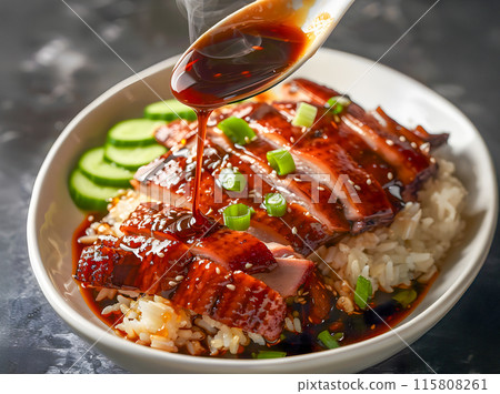 Close-up of roast duck topped with sauce on rice. 115808261