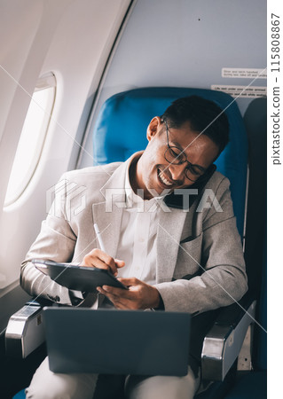 Airplane, travel and portrait of businessman working on laptop computer and smartphone while sitting in airplane. Airplane, travel and portrait of businessman working on laptop computer and smartphone while sitting in airplane. 115808867