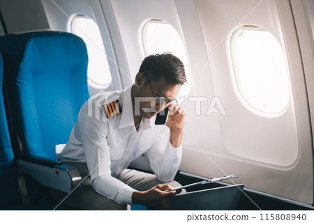 .Portrait of a trained airplane captain in uniform preparing to fly in a simulator cockpit. .Portrait of a trained airplane captain in uniform preparing to fly in a simulator cockpit. 115808940