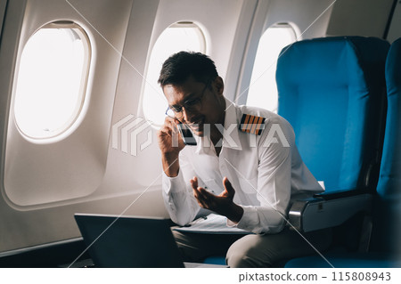 .Portrait of a trained airplane captain in uniform preparing to fly in a simulator cockpit. 115808943