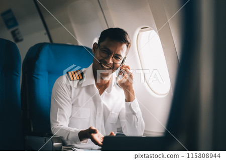 .Portrait of a trained airplane captain in uniform preparing to fly in a simulator cockpit. 115808944
