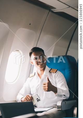 .Portrait of a trained airplane captain in uniform preparing to fly in a simulator cockpit. .Portrait of a trained airplane captain in uniform preparing to fly in a simulator cockpit. 115808945