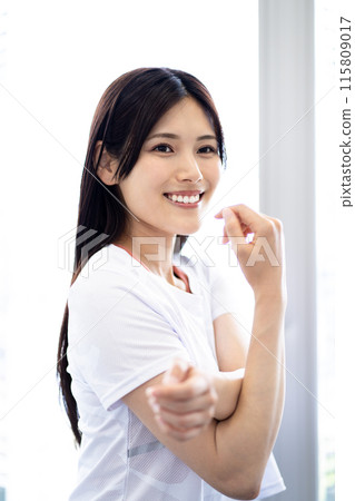 伸展運動的女性肖像（白色短袖健身服和黑色長髮） 115809017