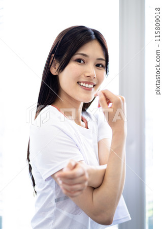 伸展運動的女性肖像（白色短袖健身服和黑色長髮） 115809018