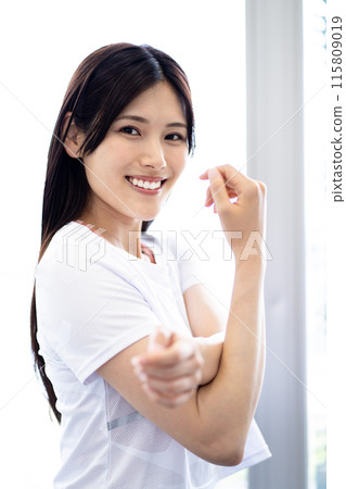 伸展運動的女性肖像（白色短袖健身服和黑色長髮） 115809019