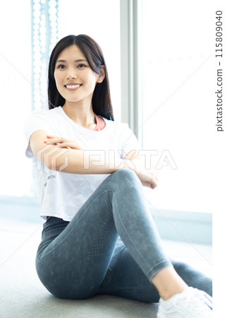 Portrait of a woman stretching (white short-sleeved fitness wear and long black hair) 115809040