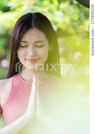 Woman doing yoga in green park (outdoor portrait, hands together in prayer, concentration, relaxation) Woman doing yoga in green park (outdoor portrait, hands together in prayer, concentration, relaxation) 115809206