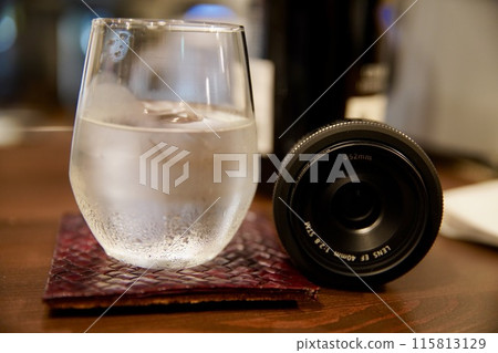 Glass of water and camera lens 115813129