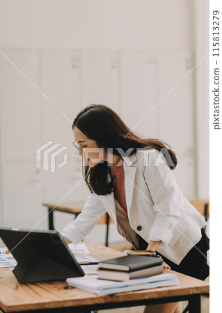 Happy young asian businesswoman sitting on her workplace in the office. Young woman working at laptop in the office. 115813279