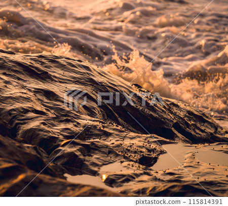 A large rocks surrounded by waves of the ocean A large rocks surrounded by waves of the ocean 115814391