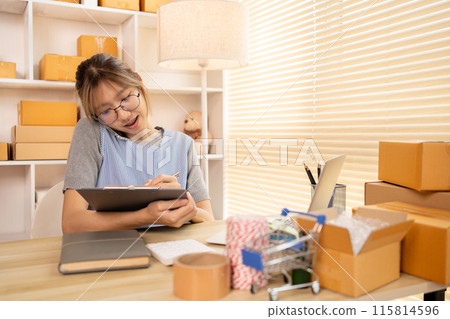 Sell products online, Young woman Multitasking: take orders from customers who call by phone, Young woman who has a lot of work and is very busy with work, Freelance working. Sell products online, Young woman Multitasking: take orders from customers who call by phone, Young woman who has a lot of work and is very busy with work, Freelance working. 115814596