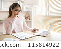Young woman using a laptop, Work from the comfort of home, Use your laptop for work and communication, Work from home. 115814922