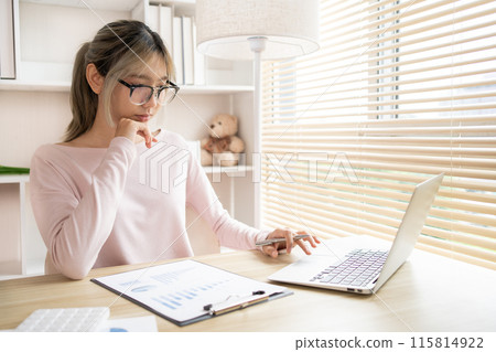 Young woman using a laptop, Work from the comfort of home, Use your laptop for work and communication, Work from home. 115814922