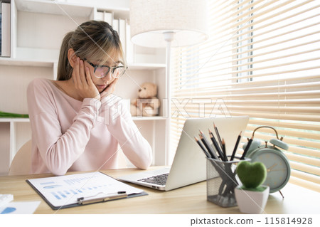 Young woman using a laptop, Work from the comfort of home, Use your laptop for work and communication, Work from home. 115814928