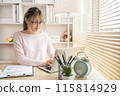 Young woman using a laptop, Work from the comfort of home, Use your laptop for work and communication, Work from home. 115814929