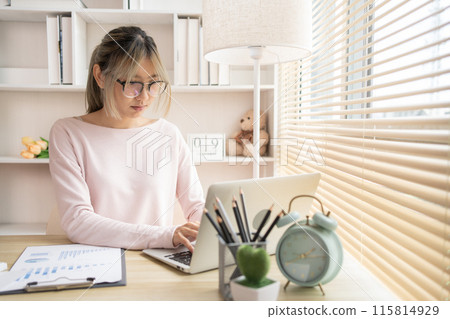 Young woman using a laptop, Work from the comfort of home, Use your laptop for work and communication, Work from home. 115814929