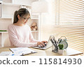 Young woman using a laptop, Work from the comfort of home, Use your laptop for work and communication, Work from home. 115814930
