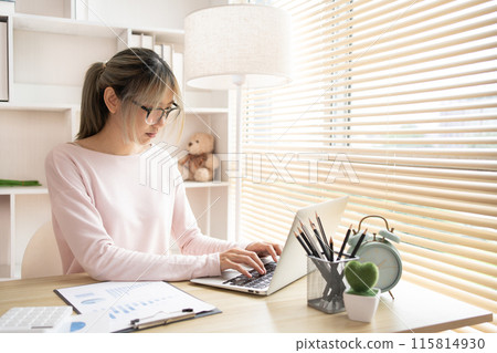 Young woman using a laptop, Work from the comfort of home, Use your laptop for work and communication, Work from home. 115814930