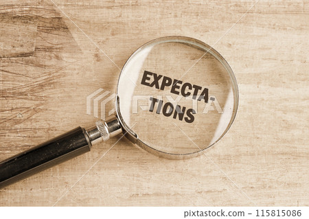 inscription Expectations word through a magnifying glass on papyrus inscription Expectations word through a magnifying glass on papyrus 115815086