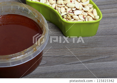 Honey in a container. Next to separate containers of peanuts and sunflower seeds. Ingredients for making halva. Honey in a container. Next to separate containers of peanuts and sunflower seeds. Ingredients for making halva. 115815342