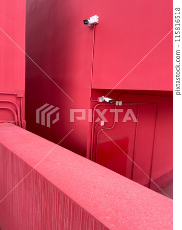 Two video cameras on the wall of the red building 115816518