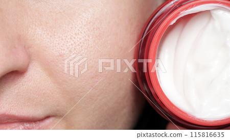 Part of a woman's face with enlarged pores and a jar of cream. Skin care. problem skin, allergies. Part of a woman's face with enlarged pores and a jar of cream. Skin care. problem skin, allergies. 115816635