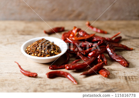 Dried red chilie and ground chilli on wooden table. Dried red chilie and ground chilli on wooden table. 115816778