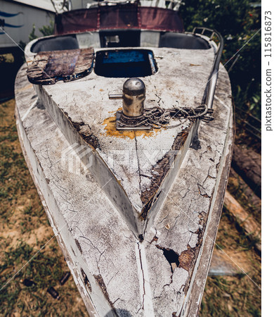 Old and rusty motor boats on a landfill surrounded by tropical forest 115816873