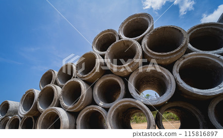 A stack of concrete ring pipes piled and creating a symmetrical arrangement 115816897