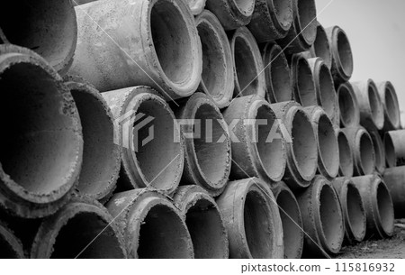 A stack of concrete ring pipes piled and creating a symmetrical arrangement A stack of concrete ring pipes piled and creating a symmetrical arrangement 115816932