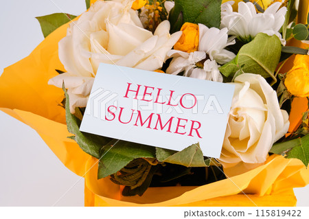 Conceptual hello summer symbol. HELLO SUMMER on a card hidden in a bouquet of beautiful flowers 115819422