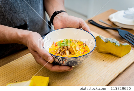 Chef at the kitchen preparing pumpkin porridge with tofu and vegetables 115819630
