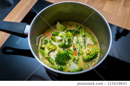 Chef at the kitchen preparing green curry with herbs and rice Chef at the kitchen preparing green curry with herbs and rice 115819643
