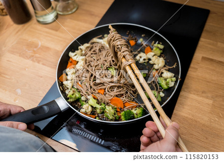 Chef at the kitchen preparing japanese buckwheat pasta with lentils Chef at the kitchen preparing japanese buckwheat pasta with lentils 115820153