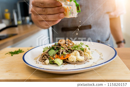 Chef at the kitchen preparing japanese buckwheat pasta with lentils Chef at the kitchen preparing japanese buckwheat pasta with lentils 115820157