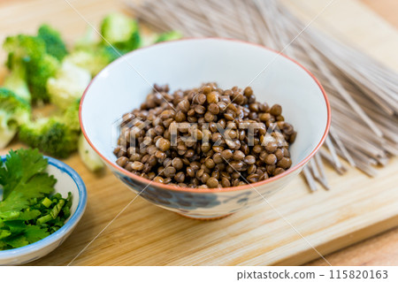 Cutting board with raw japanese buckwheat pasta and lentils 115820163