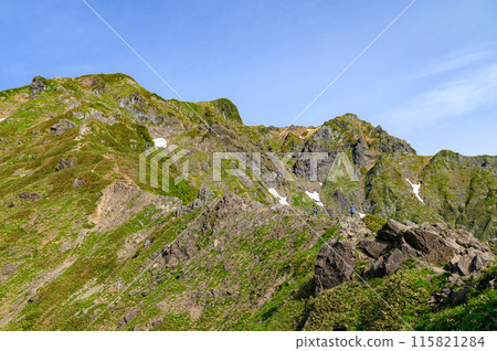 The Nishikuro Ridge of Japan's famous peak, Mt. Tanigawa, and climbers walking along the rocky terrain 115821284