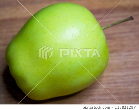 Green apple on wood, representing eco-friendly and sustainable food practices. 115821297