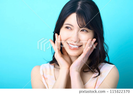 Beauty image of a woman posing in front of a blue background 115822370