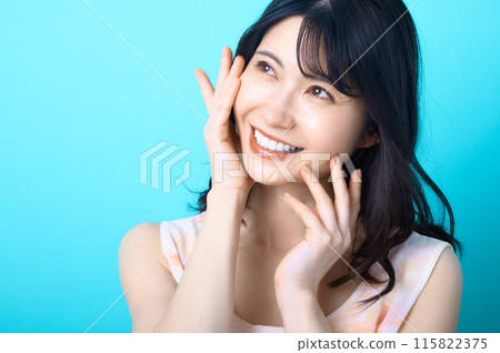 一個女人在藍色背景前擺姿勢的美麗形象 一個女人在藍色背景前擺姿勢的美麗形象 115822375