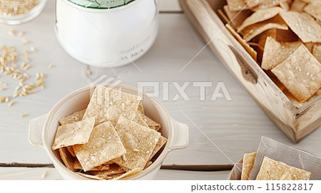 A bowl filled with crispy, seasoned crackers, perfect for snacking or serving as appetizers, displayed on a light, elegant setting.. A bowl filled with crispy, seasoned crackers, perfect for snacking or serving as appetizers, displayed on a light, elegant setting.. 115822817