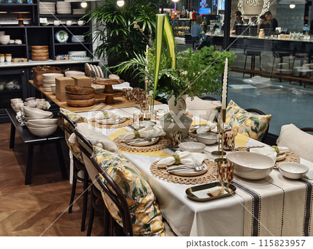 A dining room table set with plates and candles for an elegant dinner 115823957