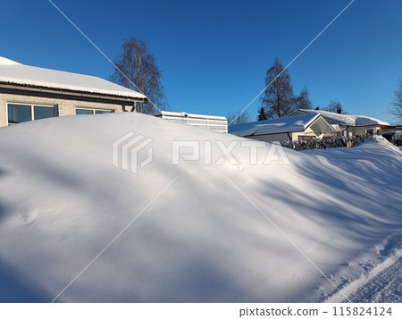 A day after the snowfall in the countryside. Sun is shining and casting shadows on the snowdrifts. Deep snow looking like a pillow. Negative degrees. Winter wonderland during January A day after the snowfall in the countryside. Sun is shining and casting shadows on the snowdrifts. Deep snow looking like a pillow. Negative degrees. Winter wonderland during January 115824124