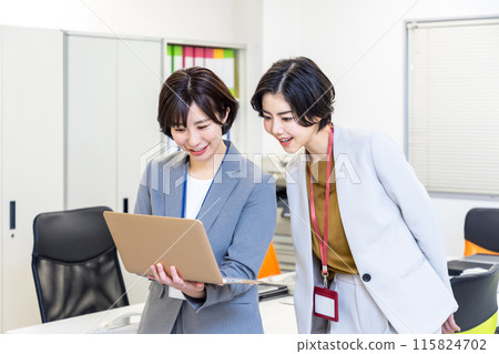 一位女士一邊看筆記型電腦一邊開會 115824702