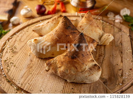Calzones on wooden board 115828139