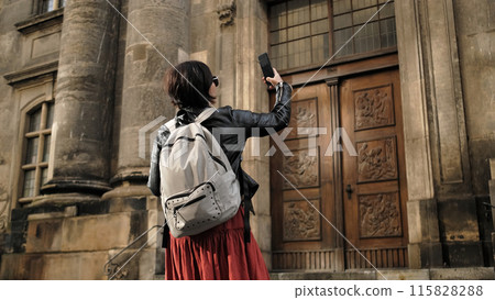 Attractive Female Tourist Walks With Germany Flag In Dresden'S Historical Center, Taking Pictures Of Sightseeing Spots 115828288