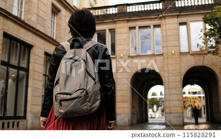 Attractive Woman Walks In City With Backpack, Looking Around 115828291