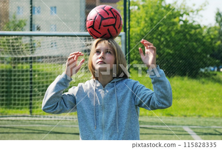 Small Girl Soccer Player Practicing With Ball On A Soccer Field 115828335